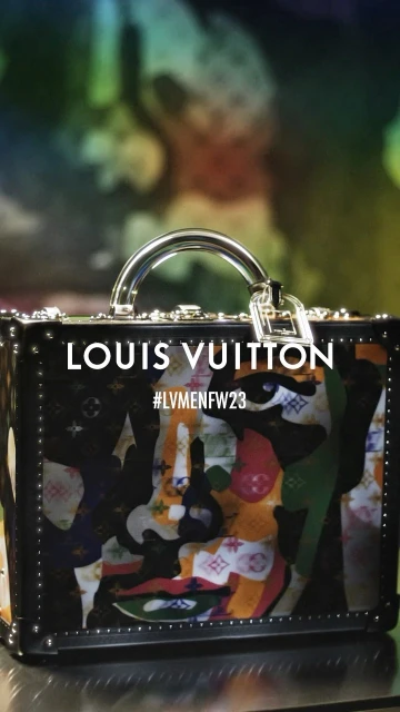 Louis Vuitton branded trunk with a graphic design in a studio setting. The brand name is prominent, with the hashtag LV Men F/W 23.