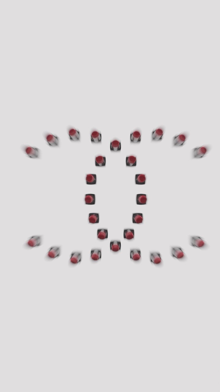 Red lipstick tubes are arranged in a repeating pattern on a bright white surface, creating an eye-catching abstract design.