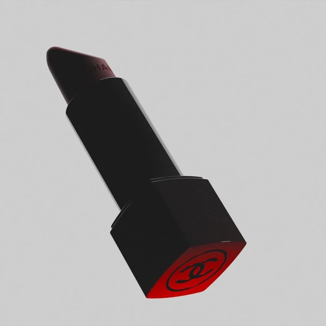 Elegant black lipstick tube with a red Chanel logo against a light gray backdrop, showcased in a visually appealing studio shot.