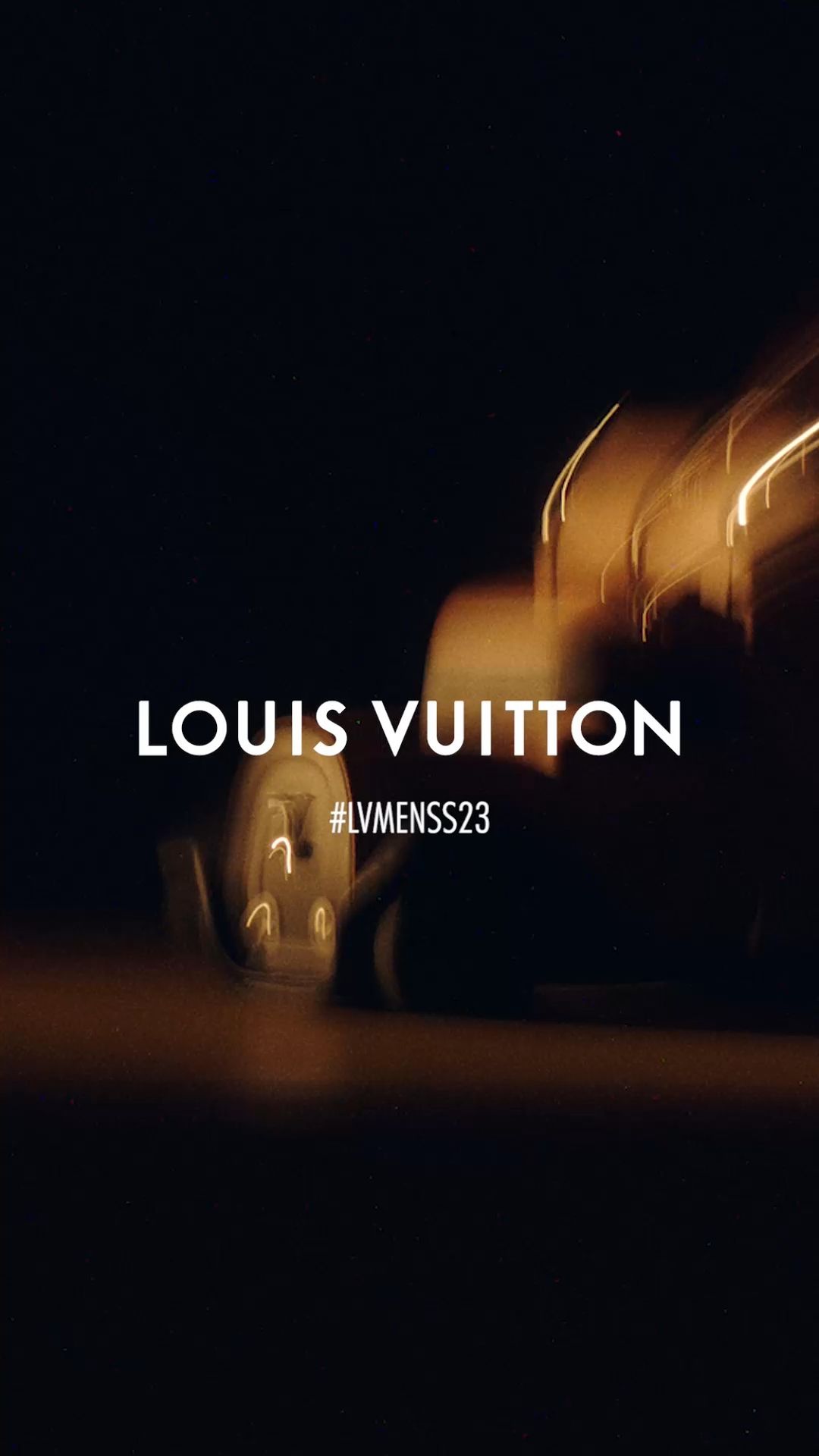 Abstract automotive advertisement featuring lights and motion blur in golden and dark tones, showcasing the brand name Louis Vuitton.
