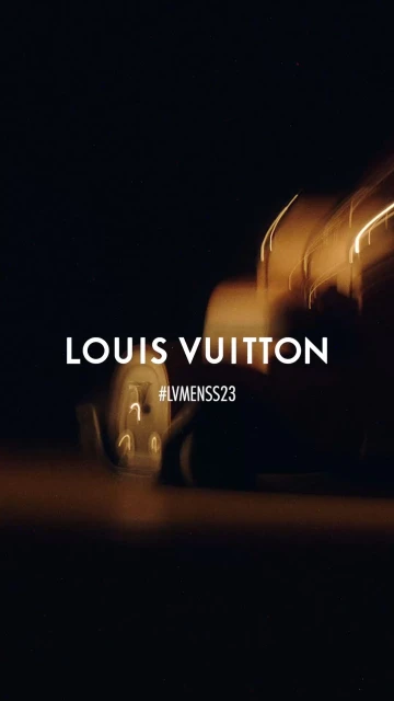 Abstract automotive advertisement featuring lights and motion blur in golden and dark tones, showcasing the brand name Louis Vuitton.