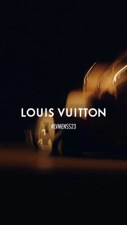 Abstract automotive advertisement featuring lights and motion blur in golden and dark tones, showcasing the brand name Louis Vuitton.