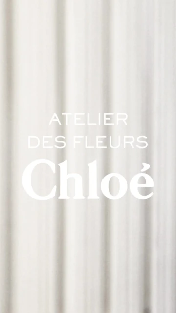 Chloe Atelier des Fleurs with soft focus on a textured white fabric background. Perfume and beauty ad with a minimalist aesthetic.