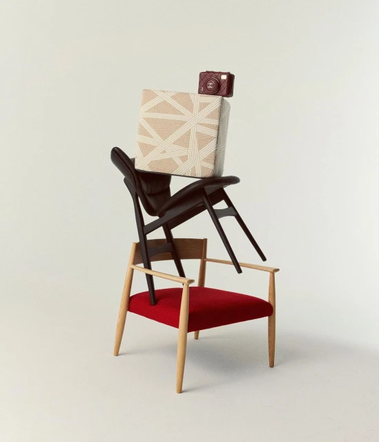 Stack of designer chairs and a decorative cube topped with a small camera in a minimalist studio with a bright, solid off-white background.