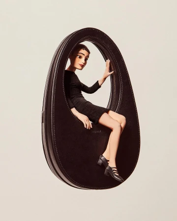 A fashion editorial image featuring a cartoon-style woman posing inside an oversized black leather handbag against a plain background.