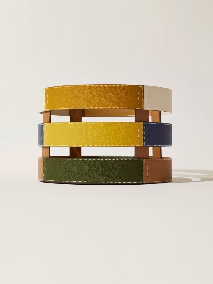 Abstract geometric table or stool featuring layered, colourful leather or fabric bands for home interior design.