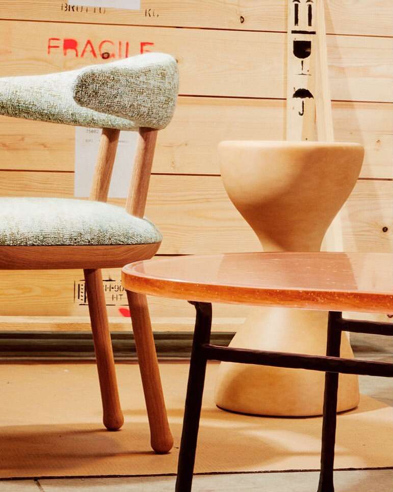 Wooden chair and round table displayed in front of a crate with red 'FRAGILE' text, creating a stylish interior design.