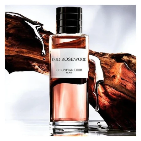 Product shot of Oud Rosewood fragrance by Christian Dior Paris, featuring a glass bottle, wooden accents, and clear liquid droplets.