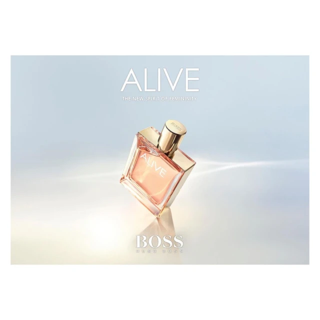 Hugo Boss Alive perfume bottle in square clear glass with metallic gold cap on a light blue and white gradient background.