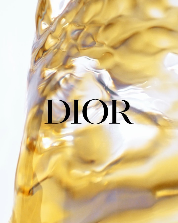 Liquid gold swirling around the Dior logo. The close-up captures the fluid movement and luxurious feel, with the brand name prominently displayed.