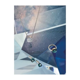 Close-up jewellery photography by Florian Joye featuring a diamond necklace, ring, and earrings displayed on geometric blue crystal prisms.
