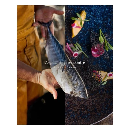 Two hands holding a fish next to a plate with composed raw fish dish; culinary fusion of fresh catch and gourmet presentation.