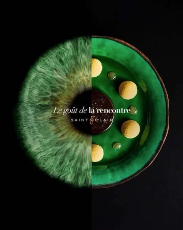 Artful food presentation on a green plate next to a digitally created green eye, all against a black background.