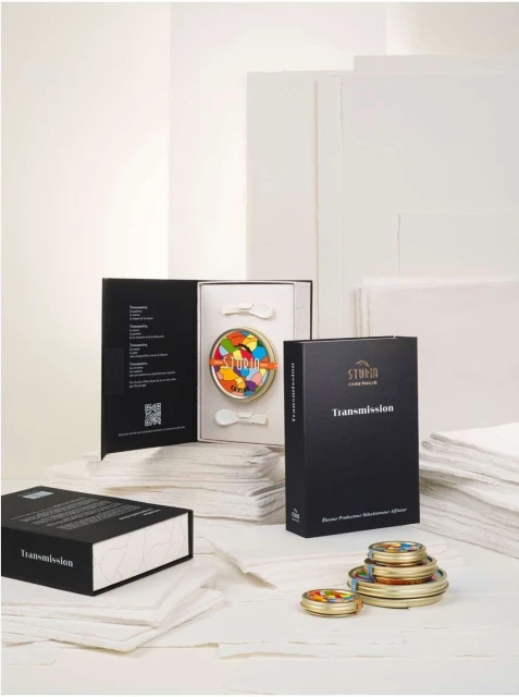 Product still life of a Sturia caviar set including tins of caviar, spoons, and product packaging, set against a white backdrop.