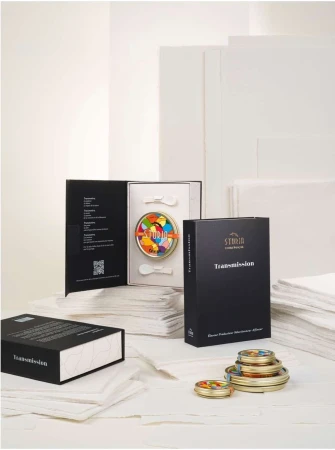 Product still life of a Sturia caviar set including tins of caviar, spoons, and product packaging, set against a white backdrop.