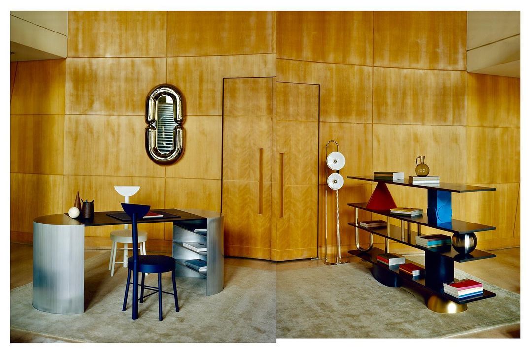 Interior design featuring an office area with a black desk, blue chair, shelving unit, and wood paneled wall in a modern style.