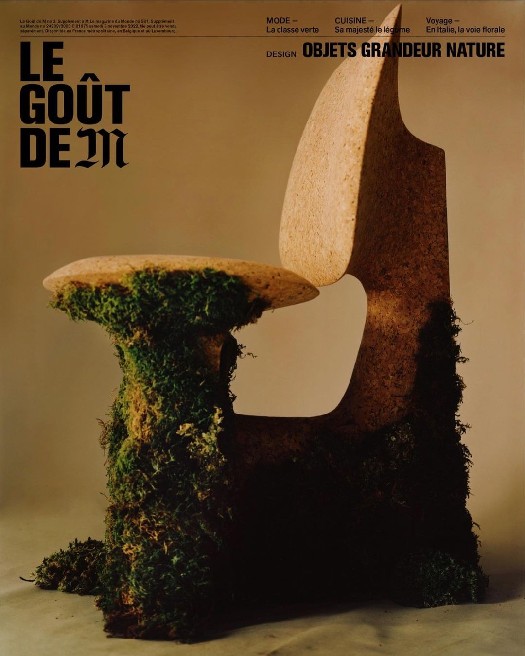 Artistic chair made of stone and moss, featured in a design magazine with headlines about fashion, cuisine, and travel.