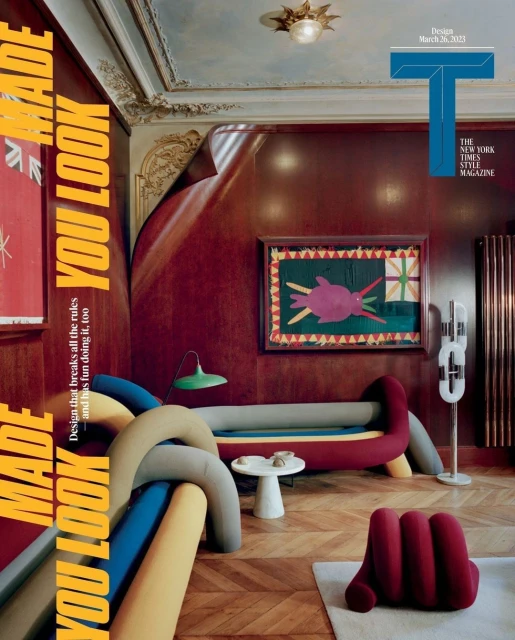 Interior design magazine cover featuring colorful furniture including a red hand chair, rounded grey sofa, and wood parquet floors.