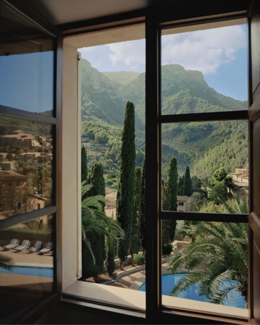 Scenic view through open window of green mountains, pool and lush palm trees, inviting outdoor vacation, perfect for tourism promotion.