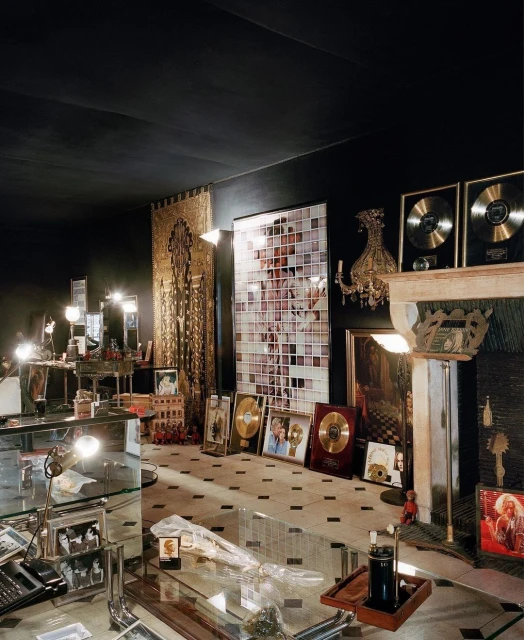 Elaborately decorated room featuring gold and platinum record awards displayed among various objects and a mosaic art piece.