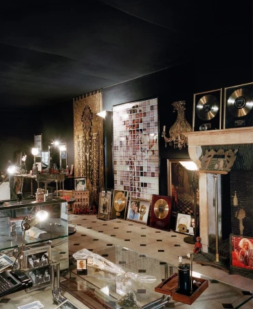 Elaborately decorated room featuring gold and platinum record awards displayed among various objects and a mosaic art piece.