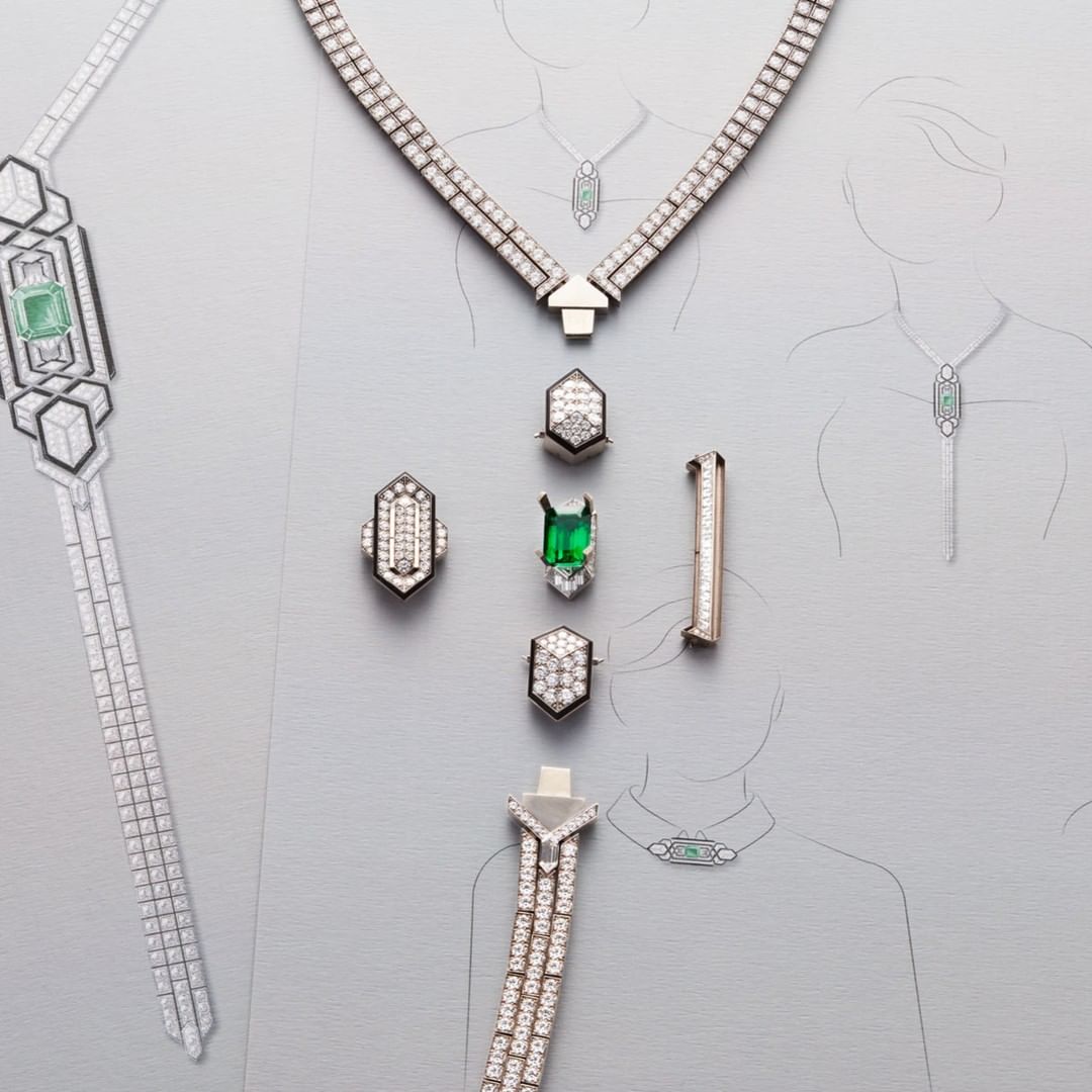Various pieces of jewelry laid out on a light gray surface, including necklaces, rings, and a brooch, complemented by sketches of jewelry.