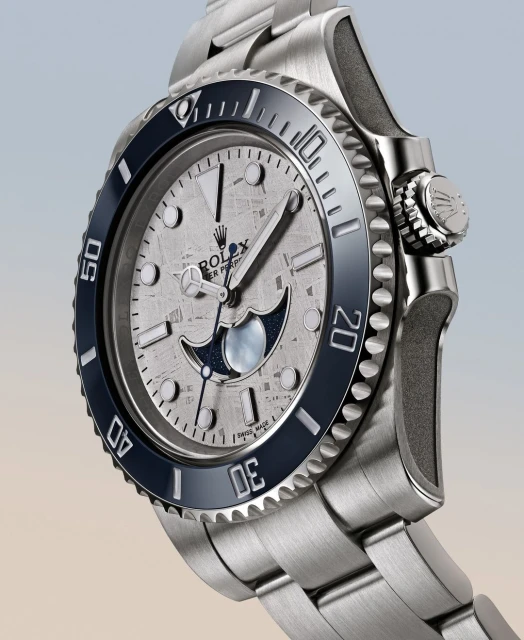 Luxury silver Rolex Submariner wristwatch with blue bezel, featuring a textured face, and silver band, displayed at an eye-level angle.