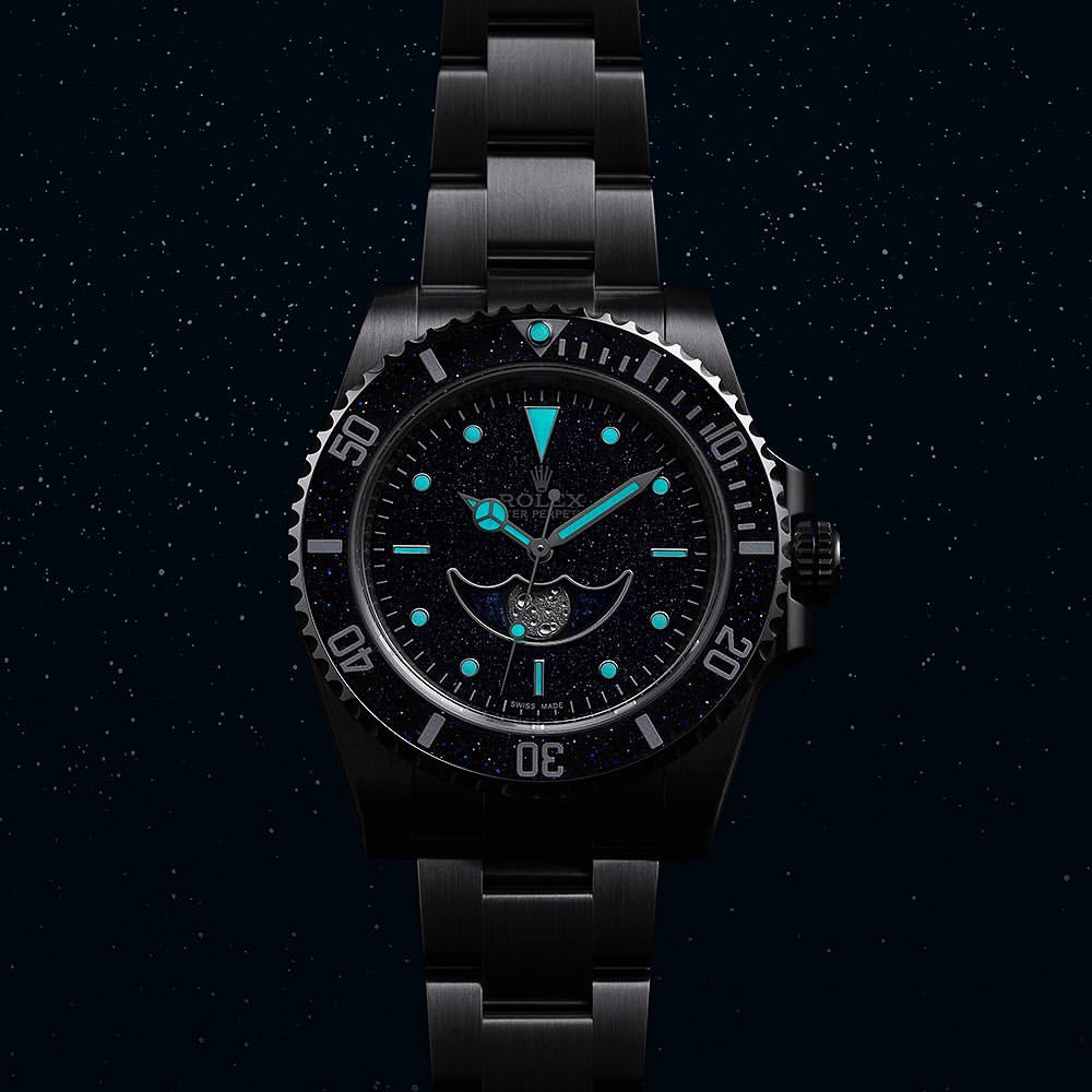 Close-up of a black Rolex watch with illuminated hands and hour markers against a starry night background, promoting a luxury timepiece.