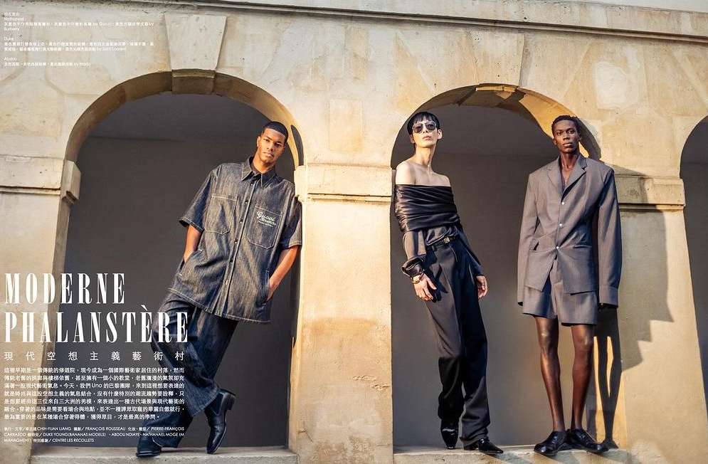 Three fashion models pose in a stone archway, showcasing modern styles. Two are dark-skinned men, one is a fair-skinned woman with sunglasses.