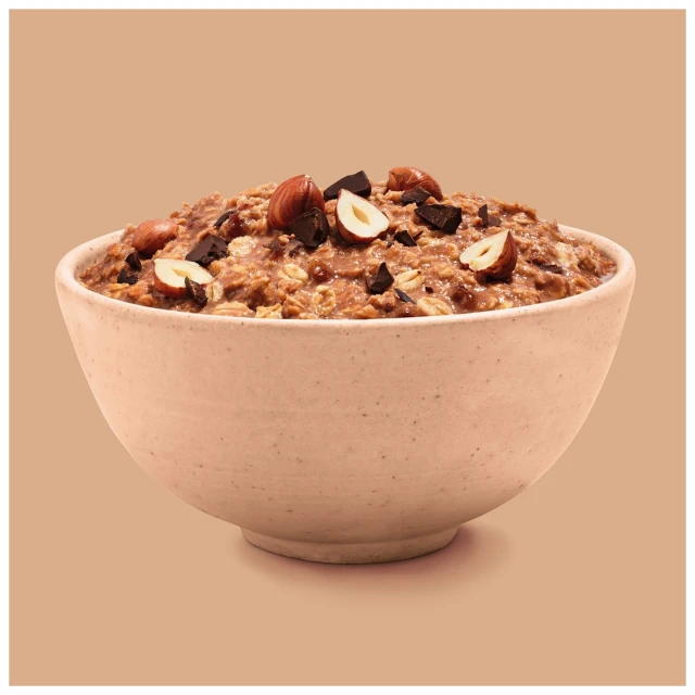 Close-up studio shot of chocolate hazelnut oatmeal in a speckled bowl, presenting a warm, inviting food photography composition.