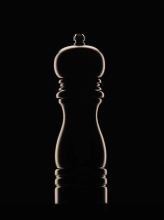 Elegant studio shot of a sleek, dark-toned pepper grinder against a stark black background, highlighted with rim lighting.