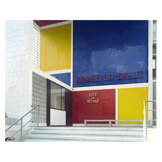 Exterior view of the Cité de refuge building in Paris, designed by Le Corbusier, showcasing its geometric shapes and vibrant primary colors.