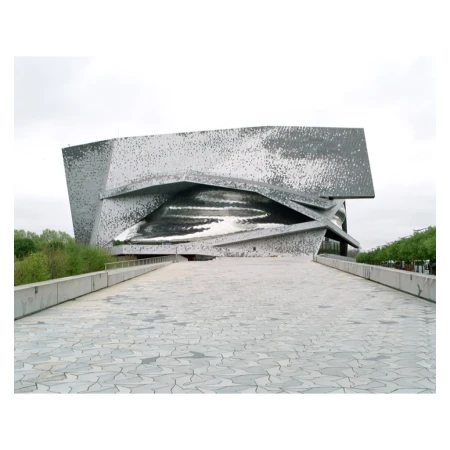 Exterior view of the Philharmonie de Paris, a modern concert hall with unique geometric design, seen on a cloudy day from the pedestrian bridge.