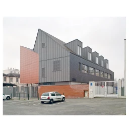 Exterior architectural photography of a modern building with zinc cladding and a parked white car in Paris by Fred Guillaud