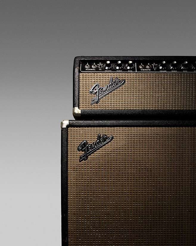 Close-up of stacked Fender guitar amplifiers with a textured grill, showcasing the iconic Fender logo and black control panels.