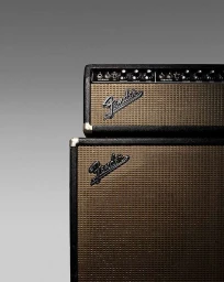 Close-up of stacked vintage Fender guitar amplifiers against a neutral grey studio background by Frederik Lindstrøm.