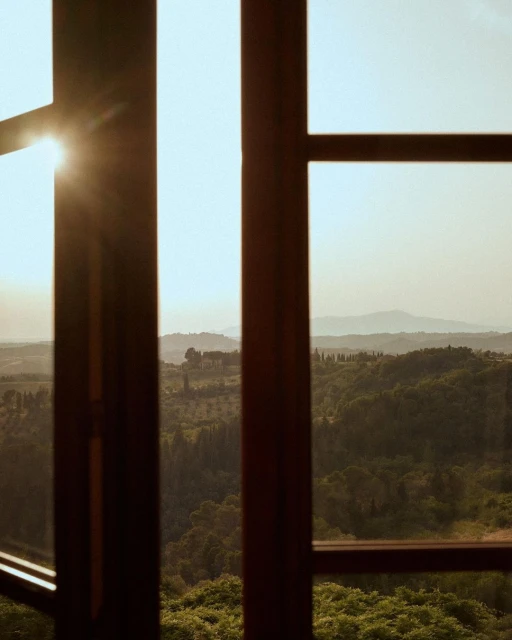 Open window view of lush green valley with soft sunlight and distant hills under a clear sky, creating a serene landscape scene.