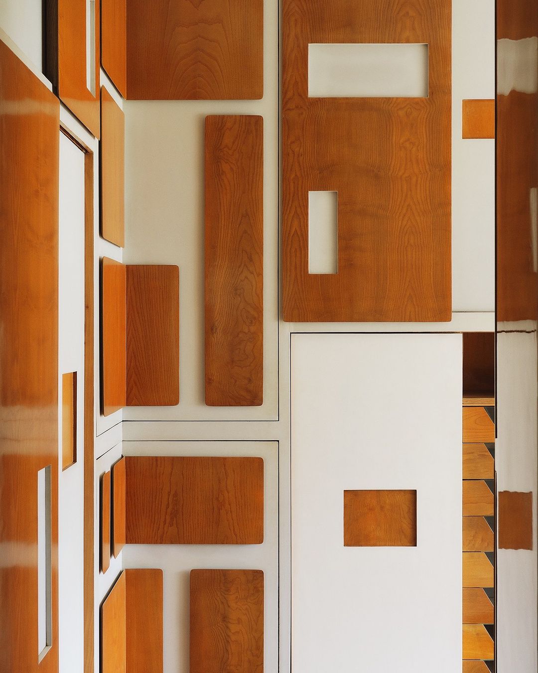 Geometric interior design with wood paneling and white walls. Abstract composition featuring rectangular and square shapes.