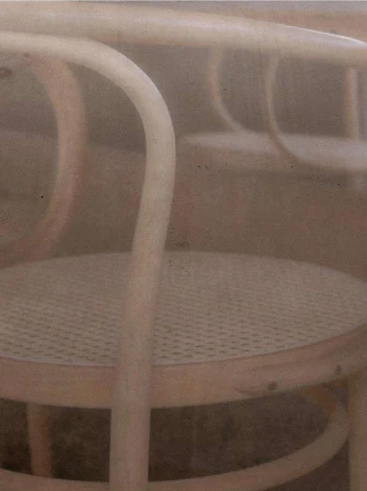 Close-up of bentwood chairs featuring rattan seating, showcasing furniture design and craftsmanship in a soft, neutral-toned composition.