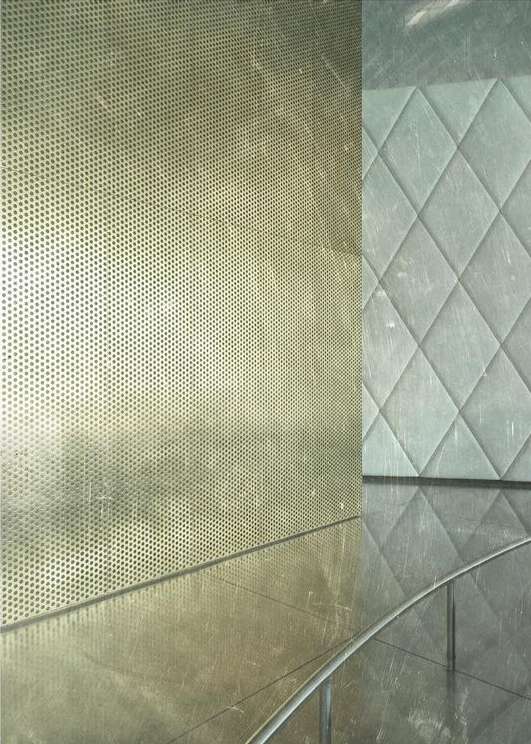 Abstract close-up shot of textured surfaces with a geometric pattern and metallic perforated wall, creating an industrial yet modern aesthetic.