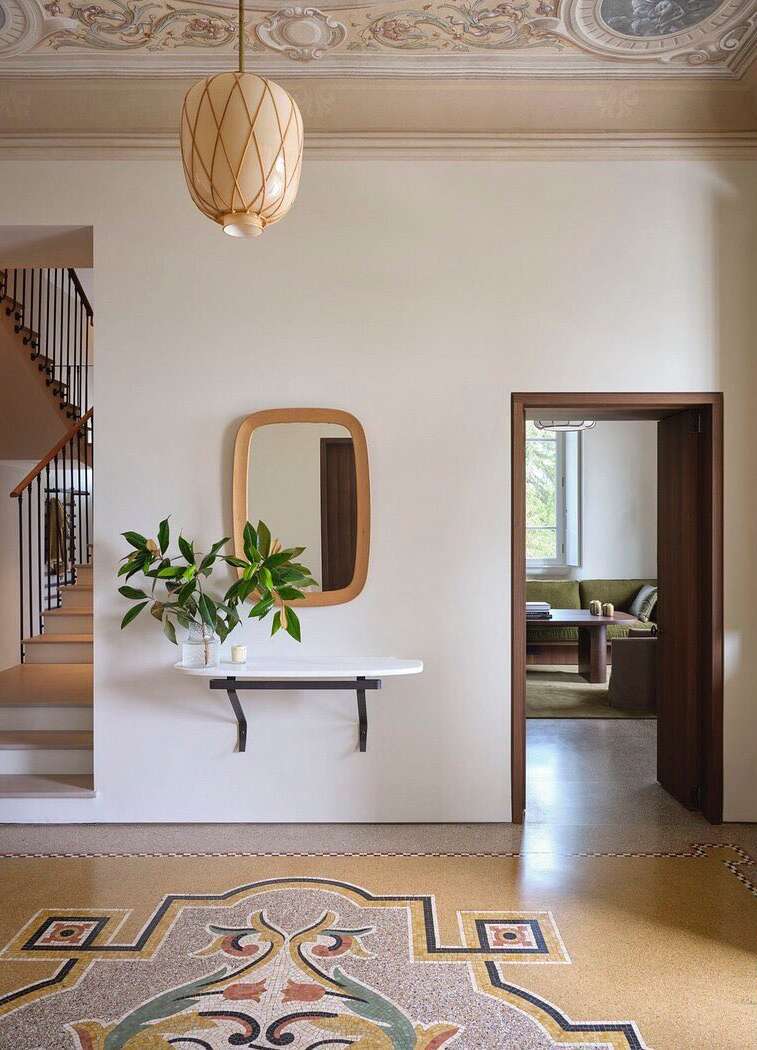 Interior view of a home featuring a terrazzo floor, a wall-mounted shelf with a mirror, and a decorative ceiling.