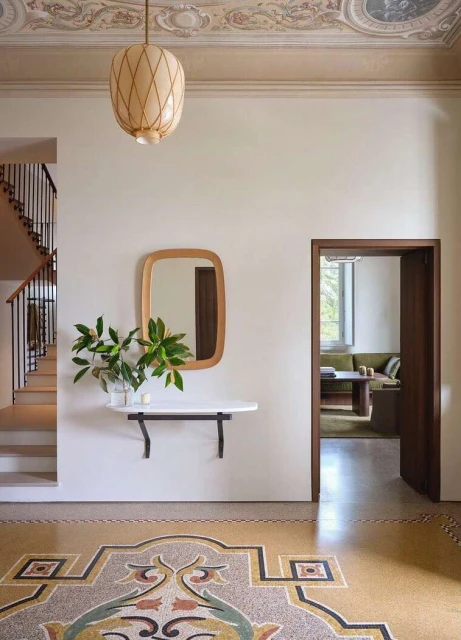 Interior view of a home featuring a terrazzo floor, a wall-mounted shelf with a mirror, and a decorative ceiling.