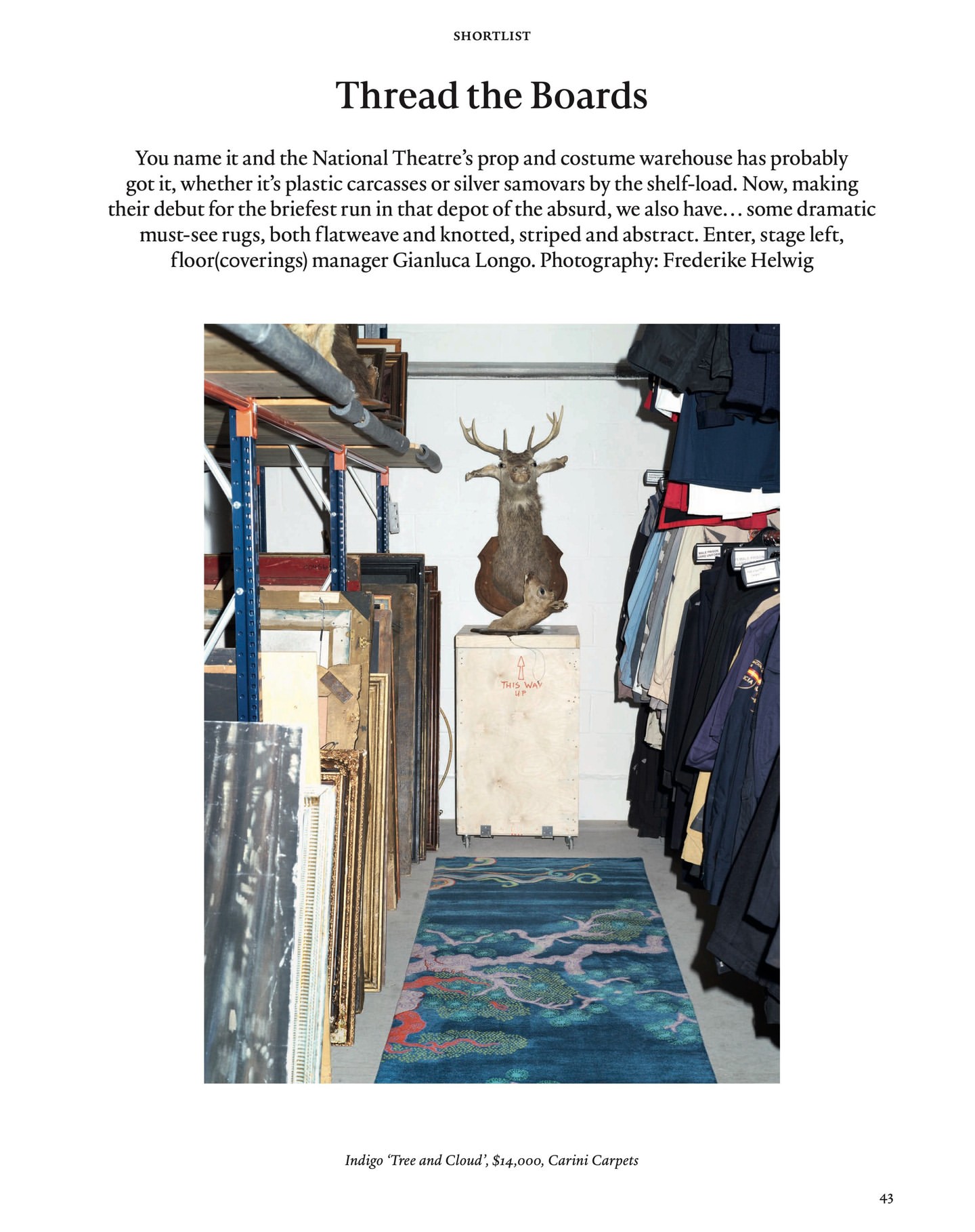 Interior shot of a prop and costume warehouse with vintage rugs, a mounted deer head, clothing racks, and shelving.