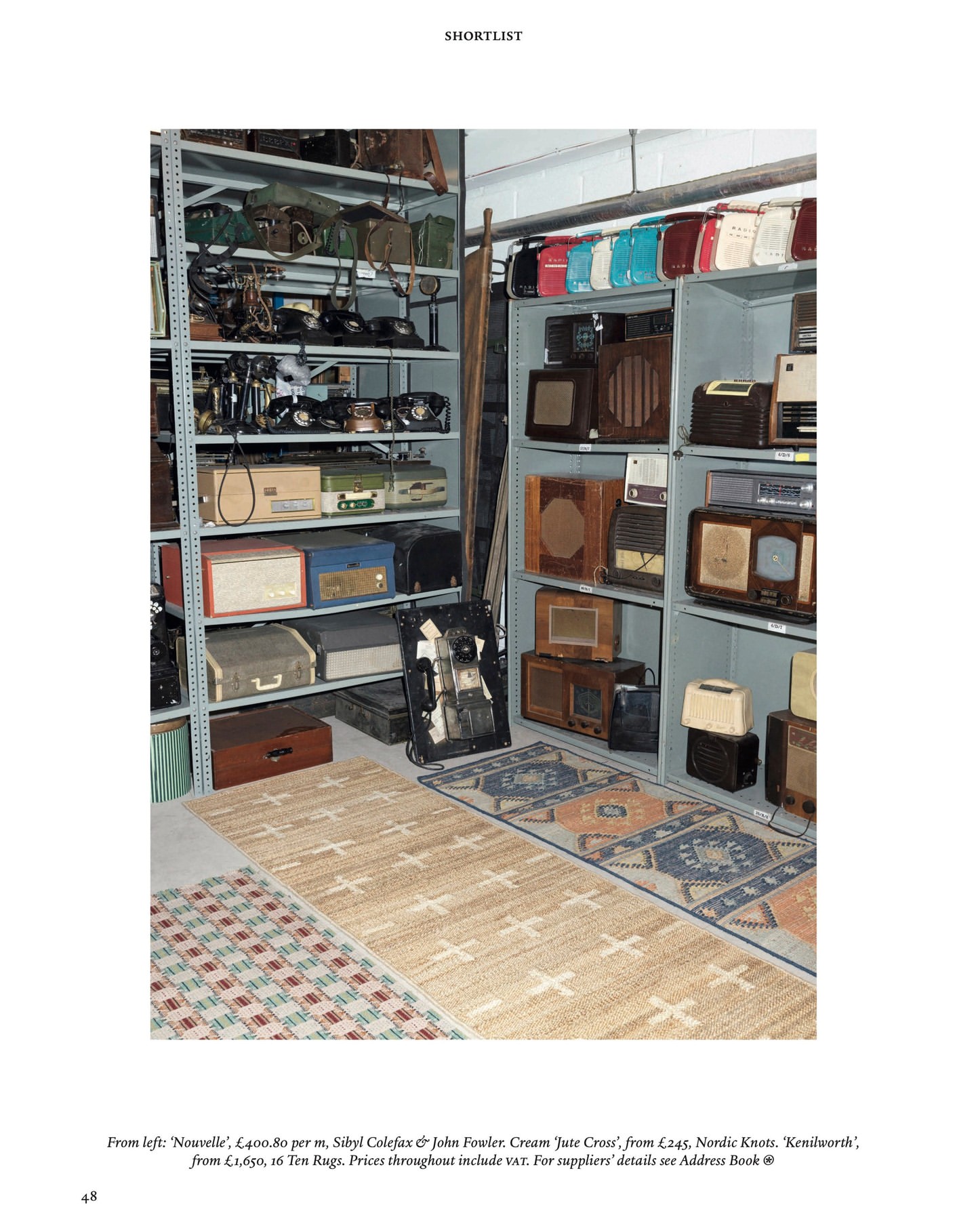 Vintage radios and bags are displayed on shelves. A variety of rugs are on the floor in front of the shelving units.