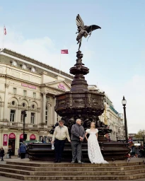 Three figures pose in front of the Shaftesbury Memorial Fountain in London, captured by photographer Frederike Helwig.