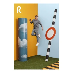 Man in grey tracksuit mid-air jumping before a split yellow and blue studio backdrop by Fredrik Broden