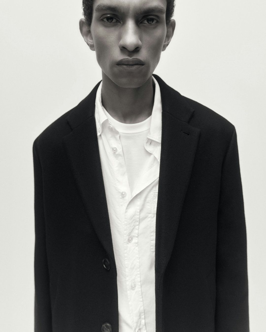Portrait of a man in a dark blazer and white shirt against a seamless background by Frida-my