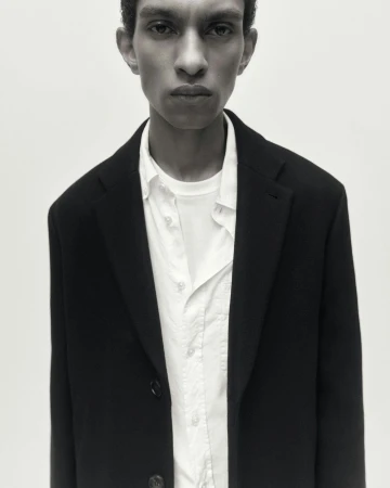 Portrait of a man in a dark blazer and white shirt against a seamless background by Frida-my