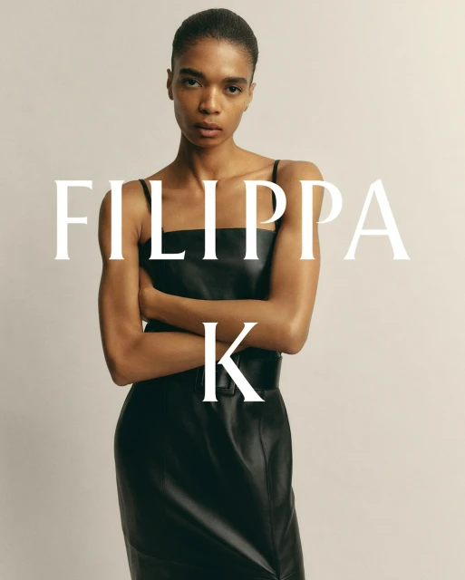 An adult fashion model poses in a black dress against a neutral backdrop, embodying a timeless style with a focus on simple elegance.