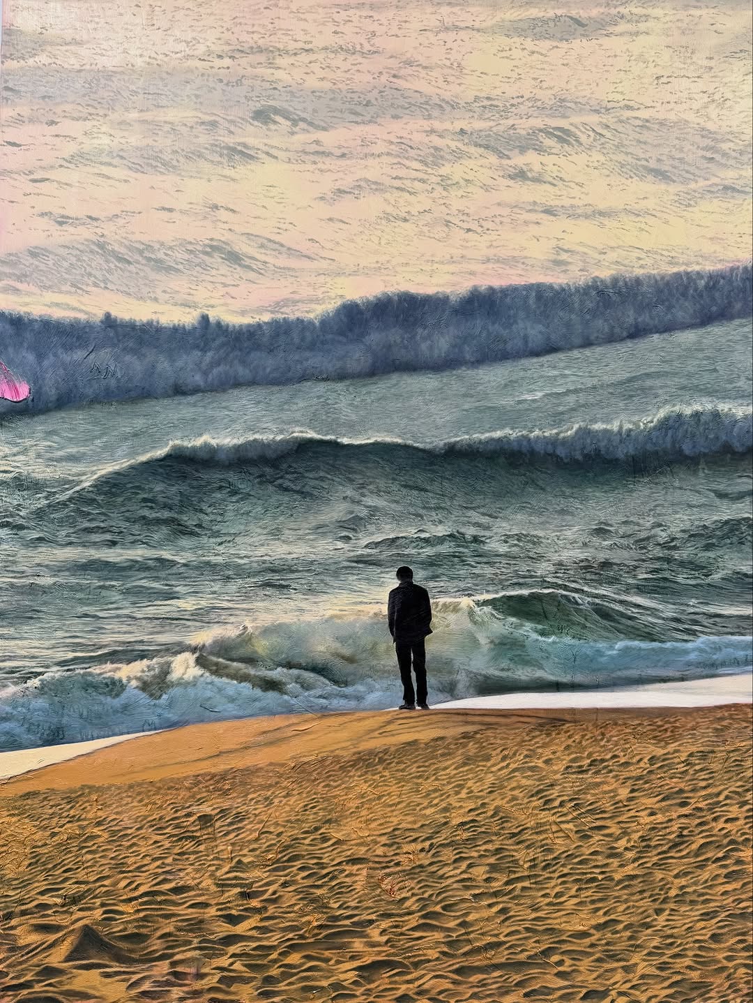 A man stands on a sandy beach looking out at a turbulent ocean with large waves under a cloudy sky, capturing a serene and reflective scene.